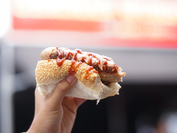 a hand holding a sausage roll