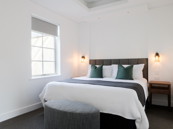 a bed beside a window at Stonewell Suite