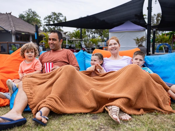 a family sitting together at the outdoor cinema of Treasure Island Holiday Resort, Gold Coast