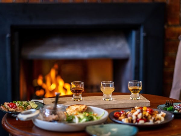 food and cocktails by the fireplace at Empire Hotel, Queenstown, Tas
