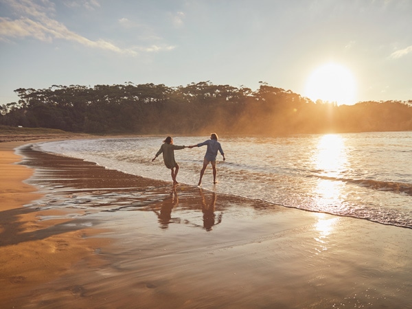 a couple holding hands at the Malua Bay Beach
