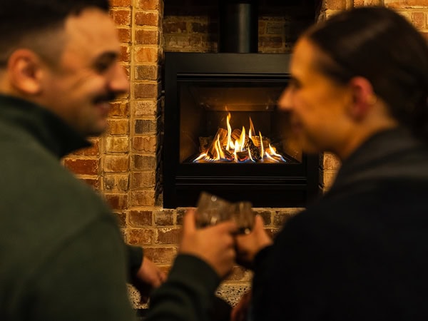 a couple talking near the fireplace at The Victoria Hotel, Rutherglen, Vic