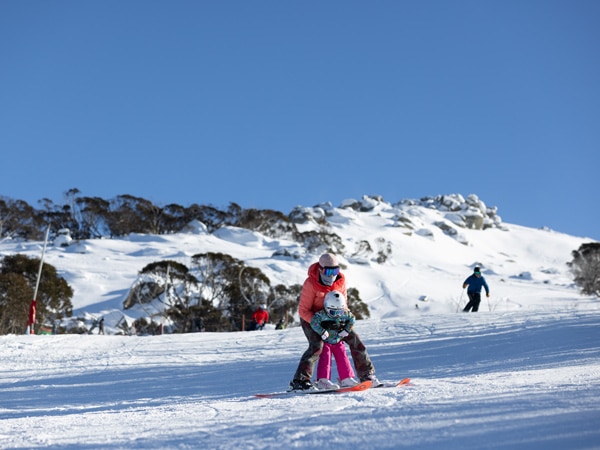 a parent and child snowboarding in Thredbo