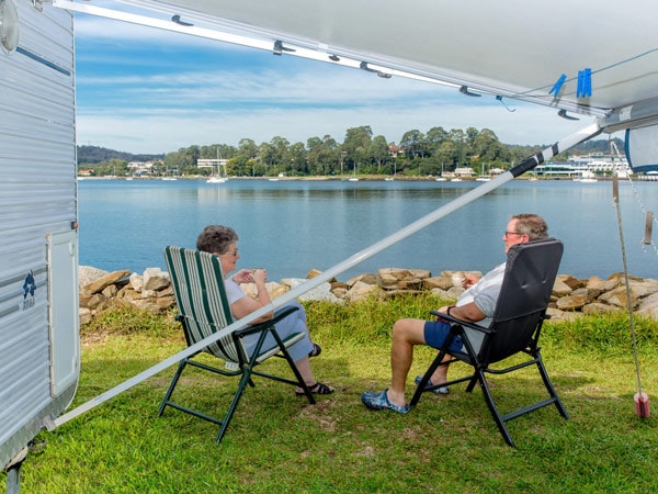 a couple sitting in a foldable chair at BIG4 Batemans Bay at East's Riverside Holiday Park