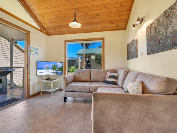 a standard cabin with a cosy sofa and tv at BIG4 Ingenia Holidays Merry Beach