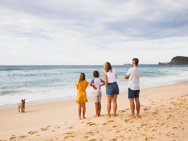 a family with a dog having fun along Blueys Beach, Barrington Coast