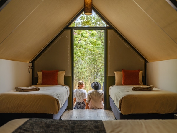 back view of two people sitting outside a cosy tent at Emma Gorge, El Questro