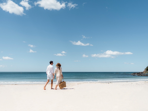 a couple walking along Forster Beach, Forster