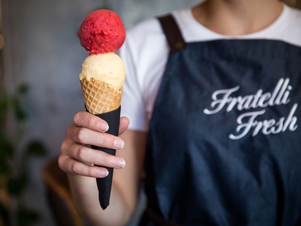 a staff at Fratelli Fresh holding a cone of gelato