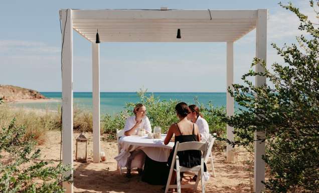 friends dining on the beachfront of Eco Beach Resort
