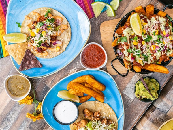 a table-top view of tacos and burritos at Hecho In Mexico