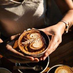 a person holding a cup of coffee at The Hungry Monkey, Kiama cafe