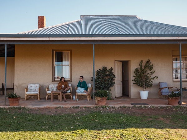 two people sitting in fornt of their accommodation at Kirkalocka Station, near Mount Magnet, WA