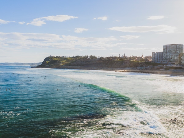 surfers in the water off Newcastle Beach
