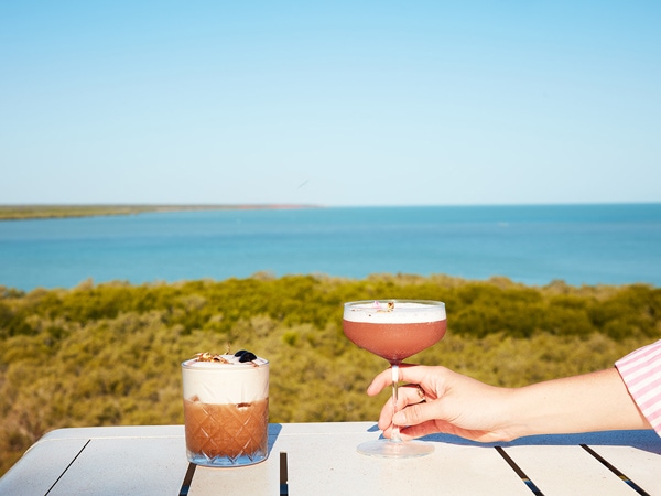 a hand holding a cocktail drink at Mangrove Hotel