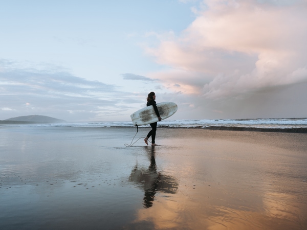 a surfer catching waves at Seven Mile Beach which stretches from Gerroa to Shoalhaven Heads