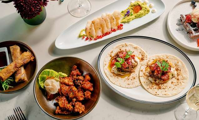 A table topped with plates of food and drinks.