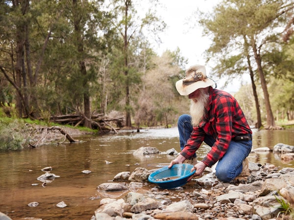 a man gold panning in the Turon River