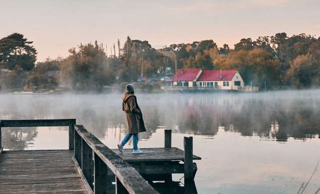 a woman standing on the edge of Lake Daylesford Bridge