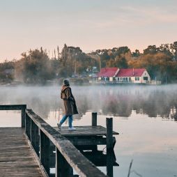 a woman standing on the edge of Lake Daylesford Bridge