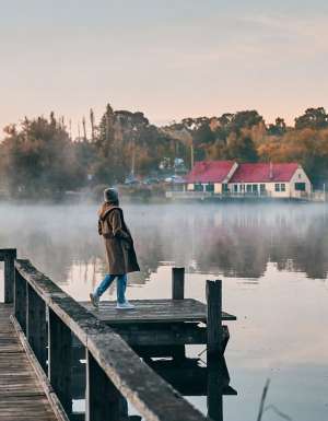 a woman standing on the edge of Lake Daylesford Bridge