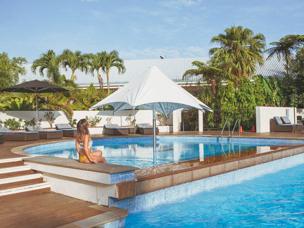 a woman relaxing by the pool at Shangri-La The Marina, Cairns