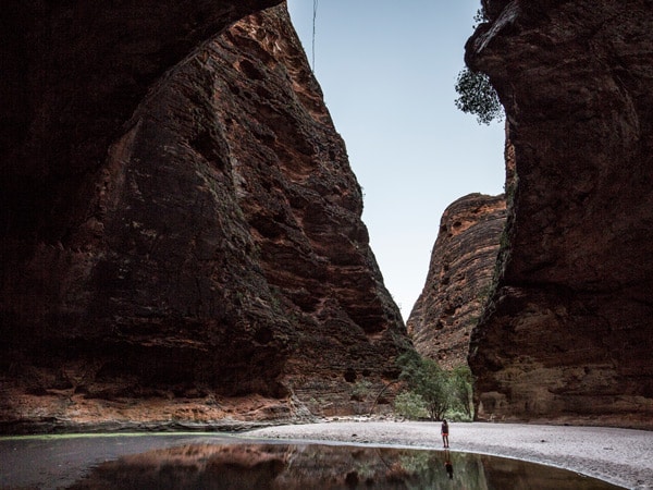 A woman stands beside the water in Cathedral Gorge