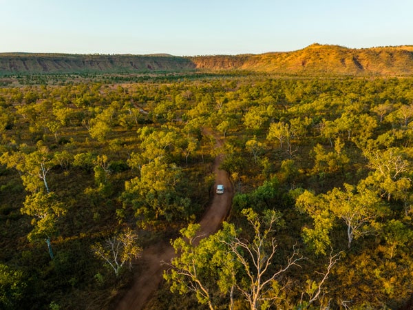 an aerial view of a vehicle driving along El Questro Wilderness Park 