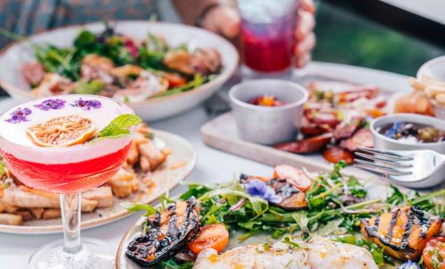 Two women drink cocktails and dine at Oak and Vine Restaurant and Bar in Cairns