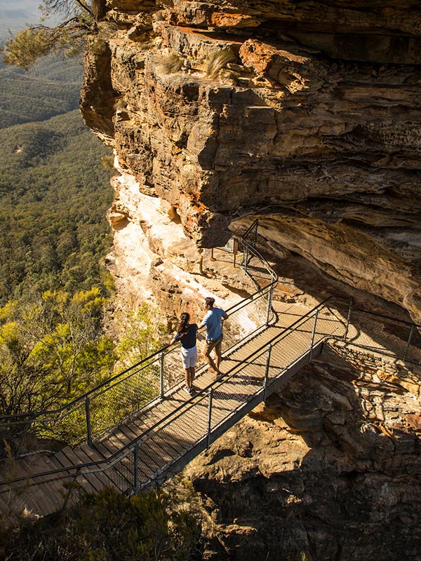 a couple enjoying views from Honeymoon Bridge overlooking the Jamison Valley along the Three Sisters Walking Trail, Katoomba
