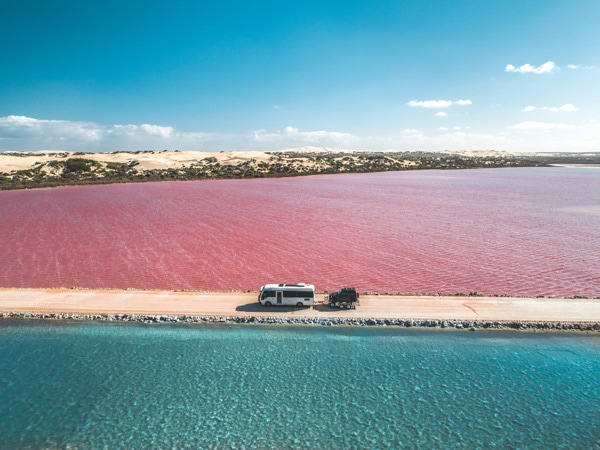 driving along pink salt Lake MacDonnell in South Australia