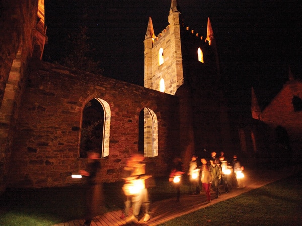 people touring around Port Arthur with lit lanterns