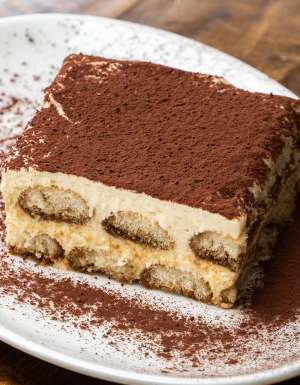 A piece of tiramisu on a white plate.