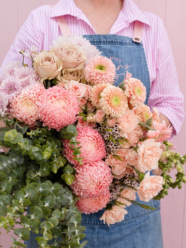 a lady holding a bunch of pink flowers at Little Miss Flowers