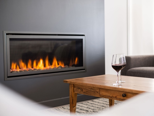 two glasses of wine on the table by the fireplace at Beach Retreat, Merewether Beach