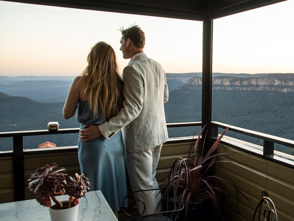 a couple admiring views over Blue Mountains National Park from Echoes Boutique Hotel and Restaurant, Katoomba