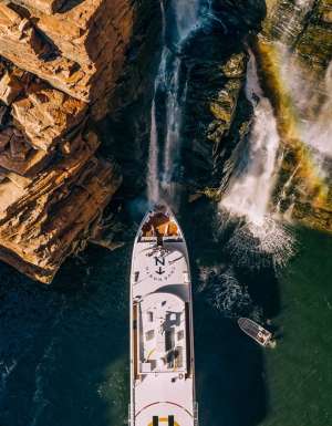 People gather on the deck under King George Falls in the Kimberley on a True North cruiise