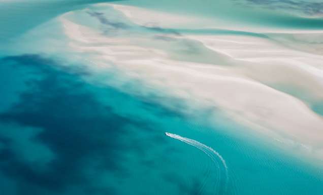Aerial view of a boat cruising through the Whitsundays