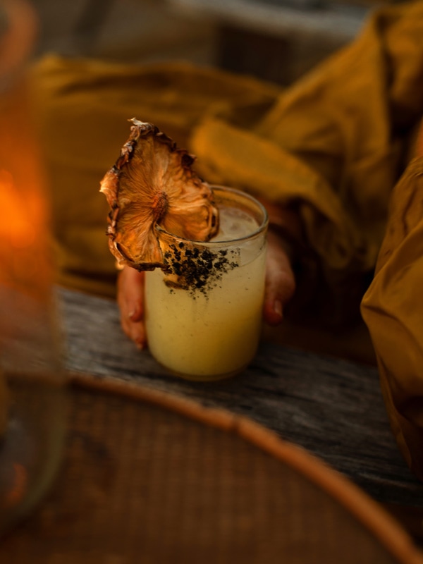 a glass of pineapple paloma