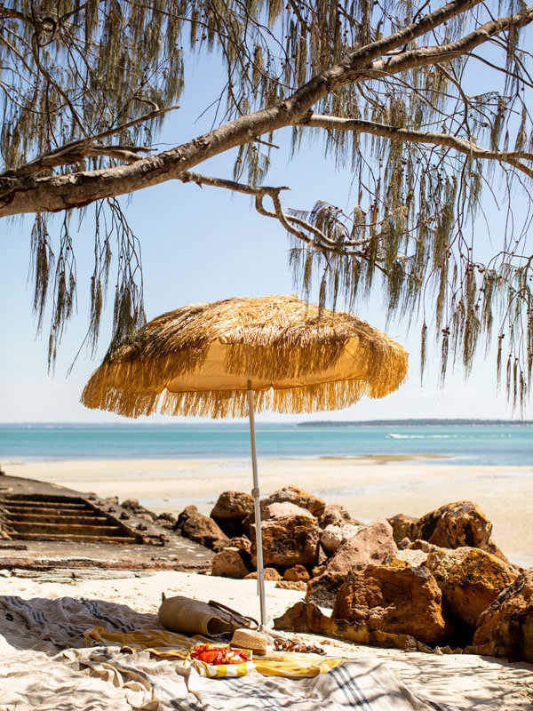 a picnic under a yellow umbrella by the beach
