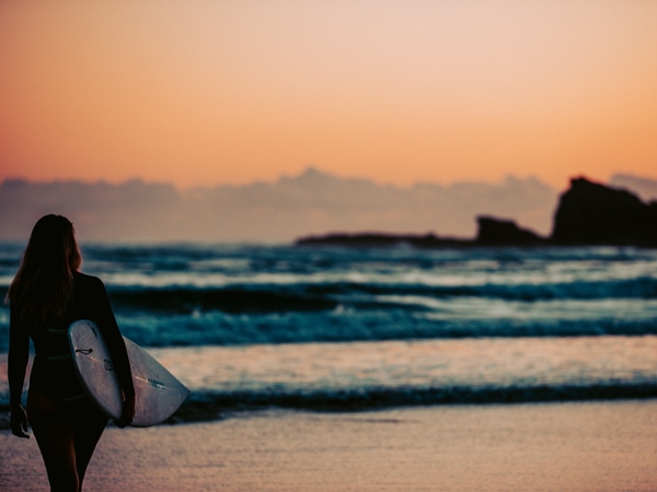 a girl heading to surf on the Gold Coast beach