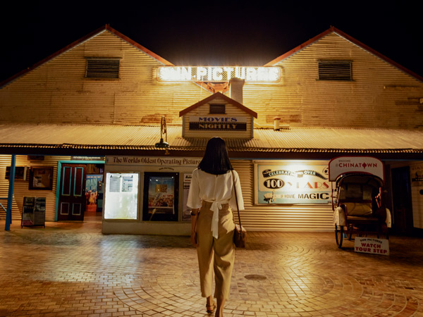 a woman standing outside Sun Pictures, Broome