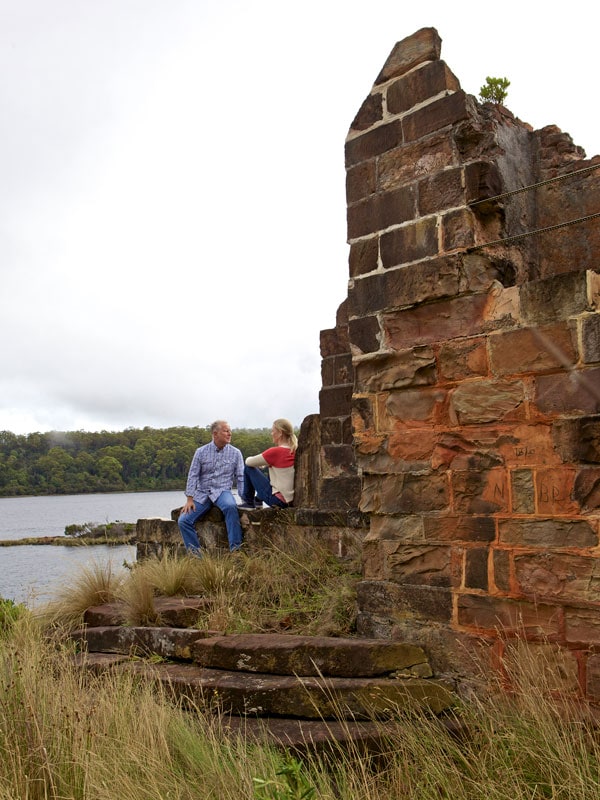 a couple sitting in the ruins of a brick structure, Gordon River Cruise