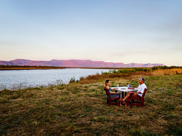 a couple dining by the side of the river at Home Valley Station