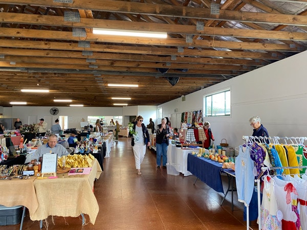 people browsing the stalls inside Oberon Community and Farmers Market