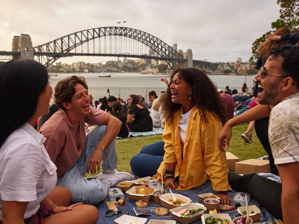 friends laughing and enjoying a picnic at Royal Botanic Gardens
