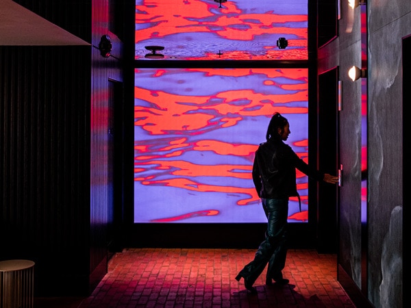 colourful lights outside the elevator in the lobby of QT Newcastle