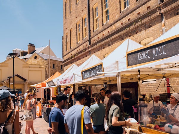 crowds browsing the food stalls at The Rocks Friday Foodie Market along Playfair Street, The Rocks