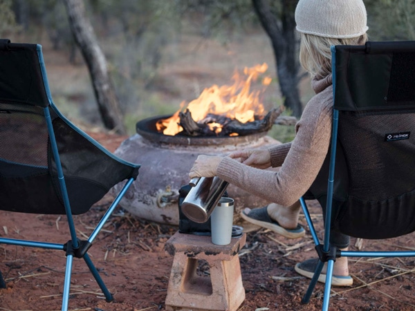 a woman sitting in front of a campfire at Ord Valley Delight