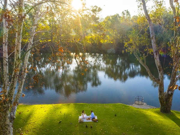 Couple enjoying a riverside picnic at Noreuil Park, Albury.